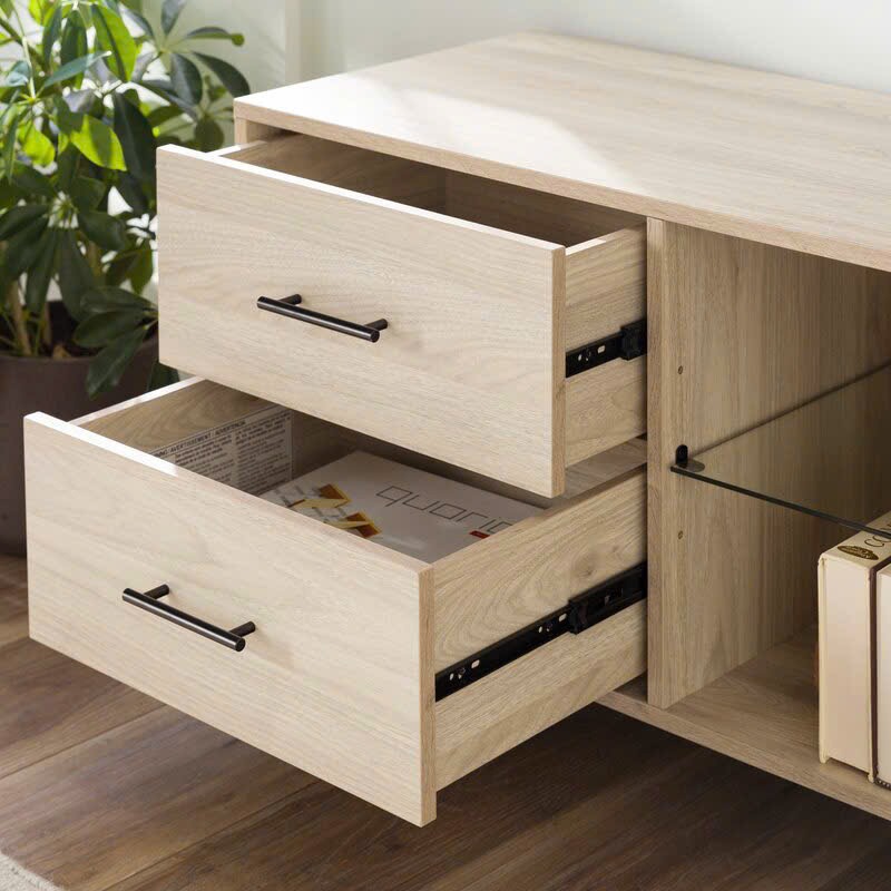 Kệ tivi làm từ gỗ công nghiệp, có 2 ngăn kéo và 2 cánh mở, thiết kế hiện đại, màu vân gỗ sáng, chân cao đen, phù hợp phòng khách tối giản.