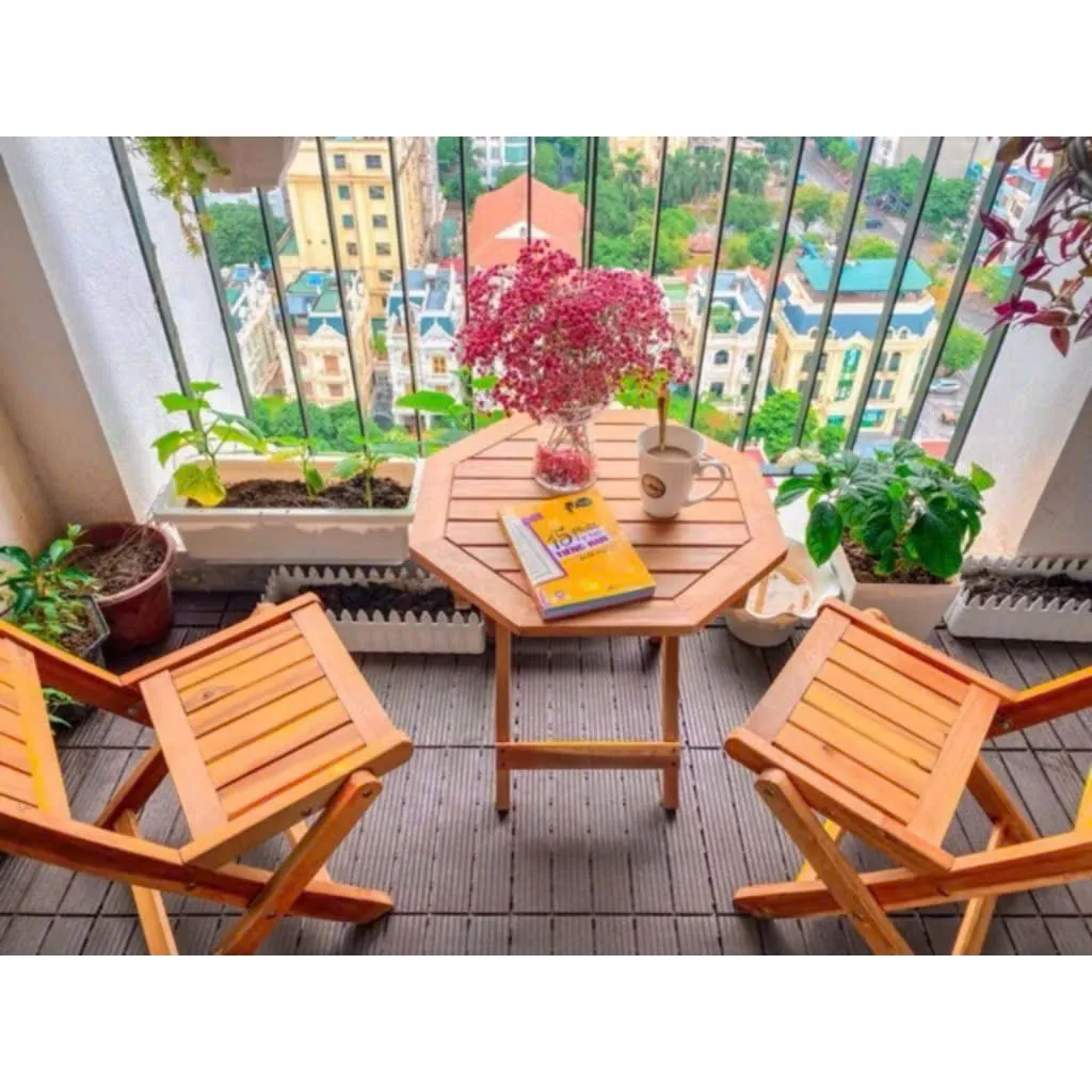 Bộ bàn ghế tiếp khách gồm bàn tròn và 4 ghế gỗ gấp gọn, thiết kế đơn giản đặt trong không gian ngoài trời, phù hợp sử dụng linh hoạt trong nhà và sân vườn